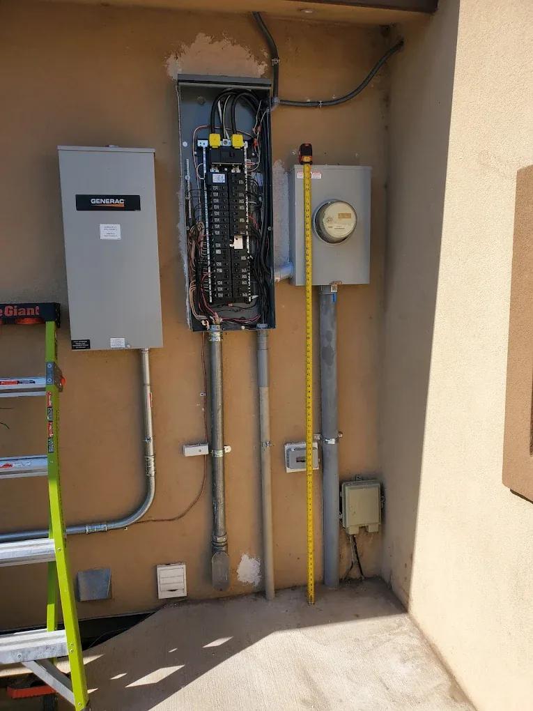 Generac automatic transfer switch installed next to a main panel and meter
