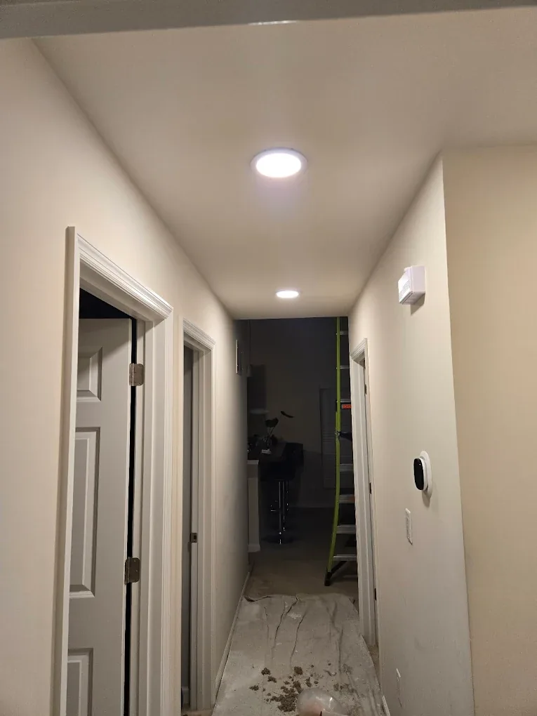 Hallway lit by cool white recessed ceiling lights
