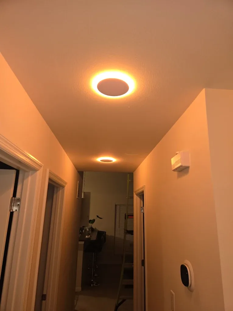 The same hallway lit by warm amber recessed ceiling lights