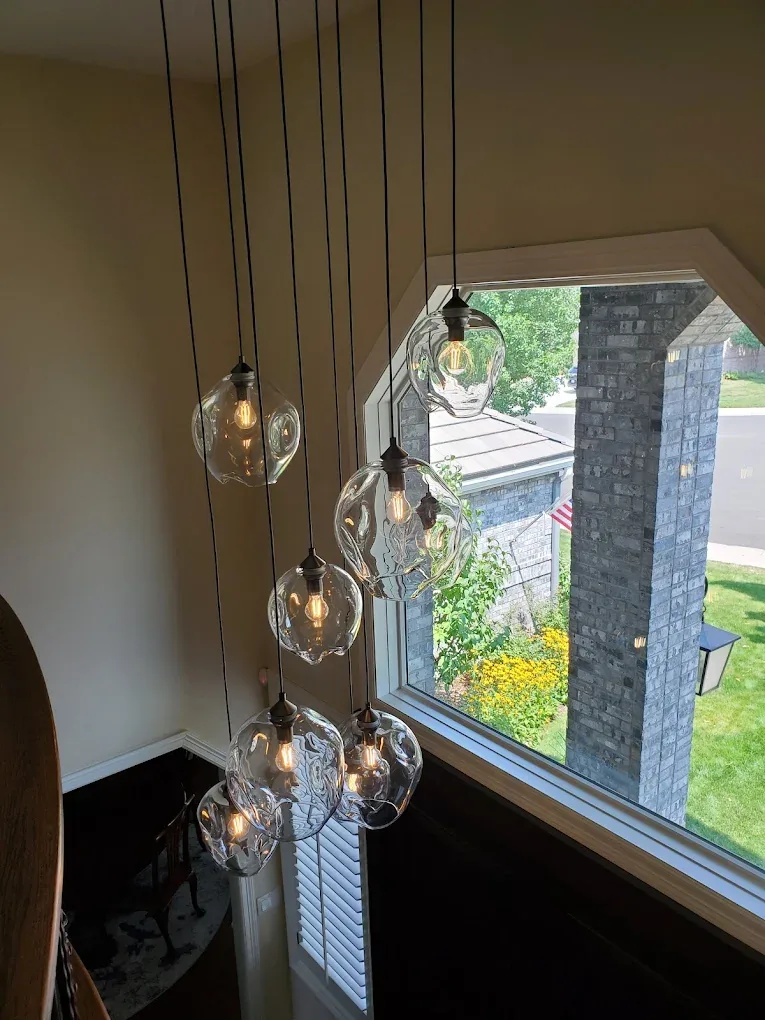 Glass globe pendants hung at staggered heights beside a tall window