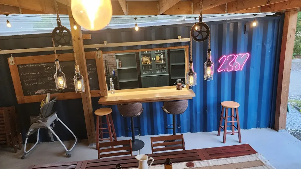 Outdoor bar lit with custom bottle pendants and neon signage